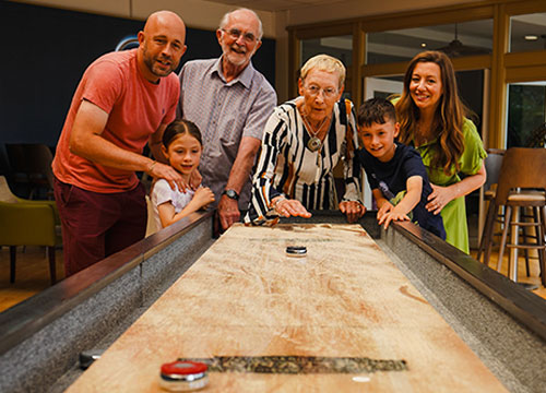 Family playing shuffleboard